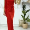 Longue Robe Rouge Avec Volant Sur Une Manche Et Accessoire Doré Au Col
