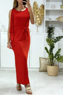 Longue Robe Rouge Avec Volant Sur Une Manche Et Accessoire Doré Au Col